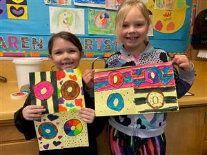 students holding art work